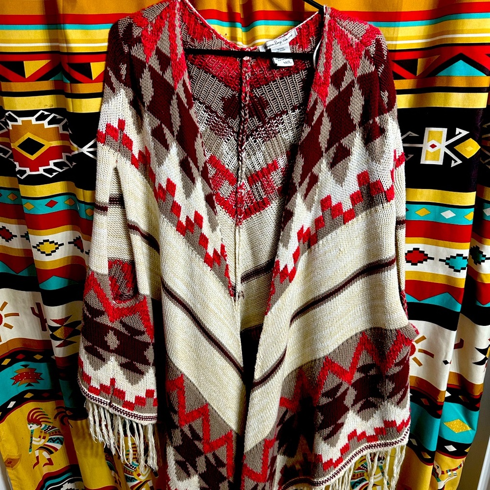 Woman’s poncho with fringe. Southwest pattern of reds, brown and cream.